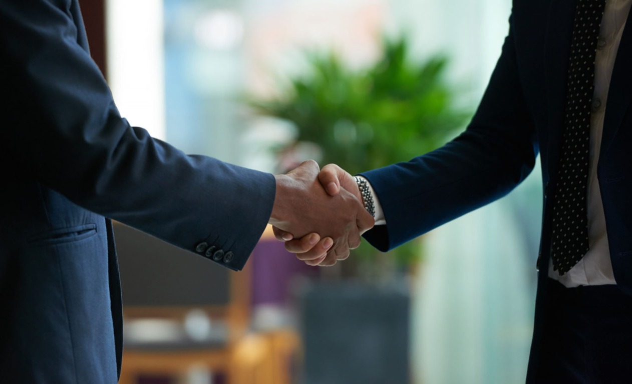 Professionals sharing a handshake in a bright office environment
